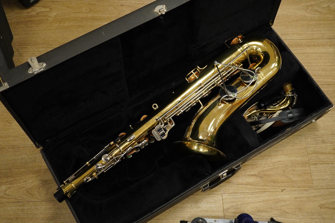 A cased Buescher Aristocrat tenor saxophone and stand